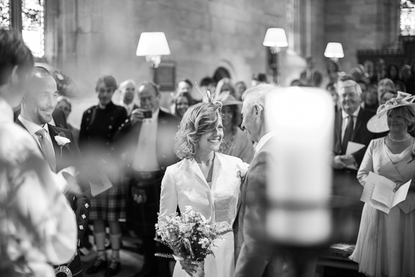 bride smiling at her father at altar