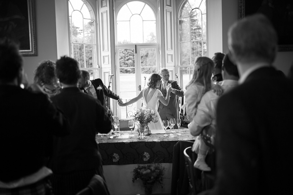 bride and groom holding hands during wedding speeches