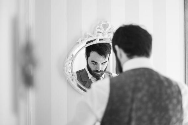 groom getting ready in front of a mirror