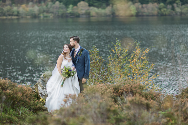 wedding photography groom is kissing bride at loch eck scotland 