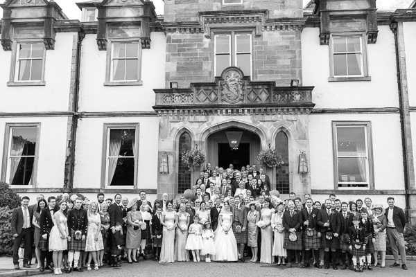 whole wedding party group at steps in front of cameron house