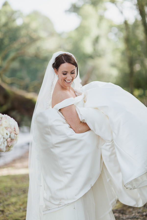 bride laughing lifting her dress at cameron hosue wedding