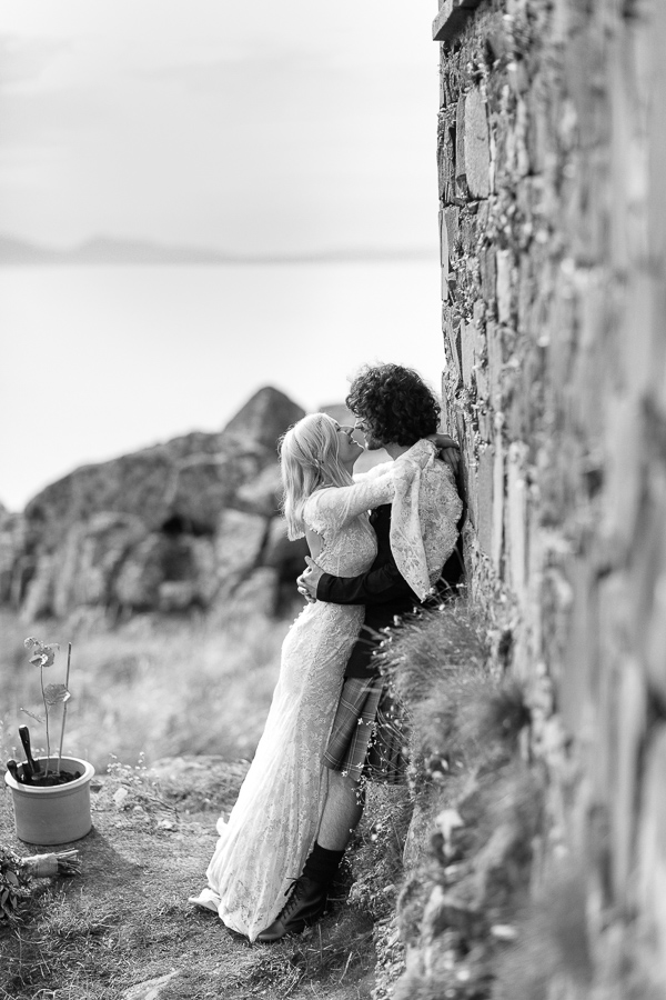 bride and groom kissing on a hill scotland