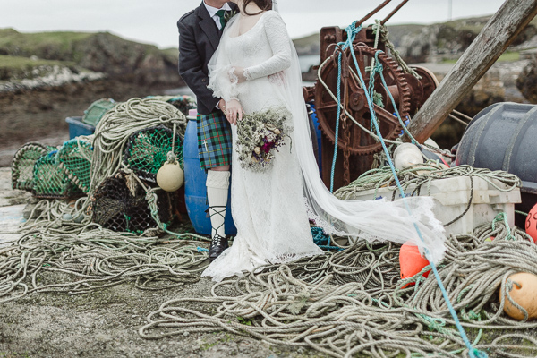 fishing robes and pier bride and groom kissing