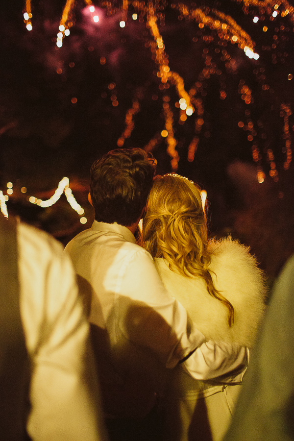 newlyweds embraced looking at fireworks display during their wedding at the lodge on loch goil in scotland